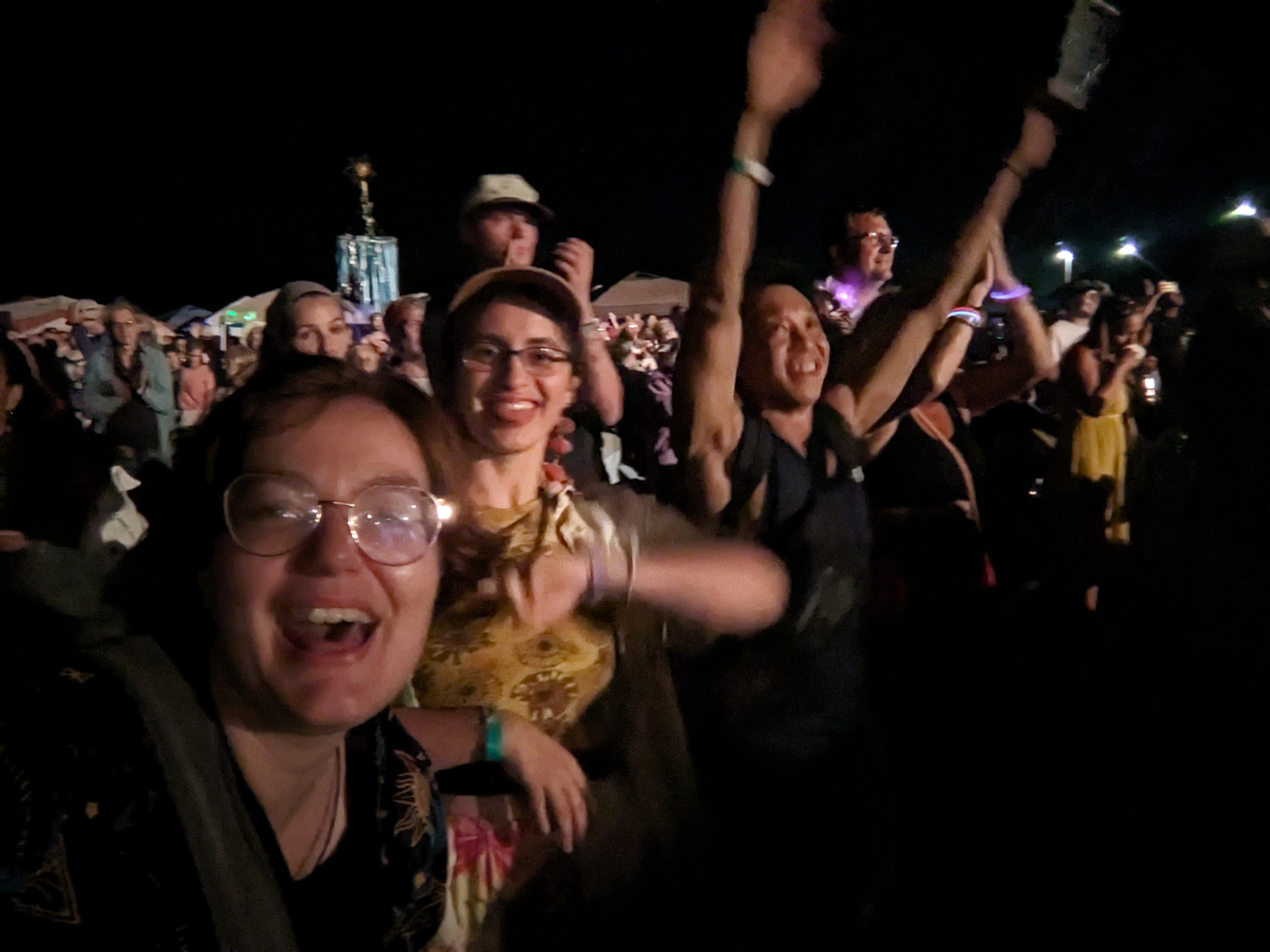 Three people enjoying themselves at a music festival.